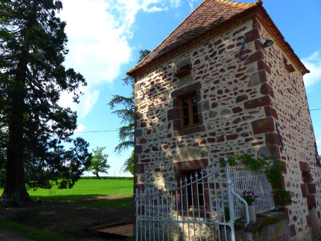 an old stone building in a field with a tree at L'Abrejou in Le Donjon