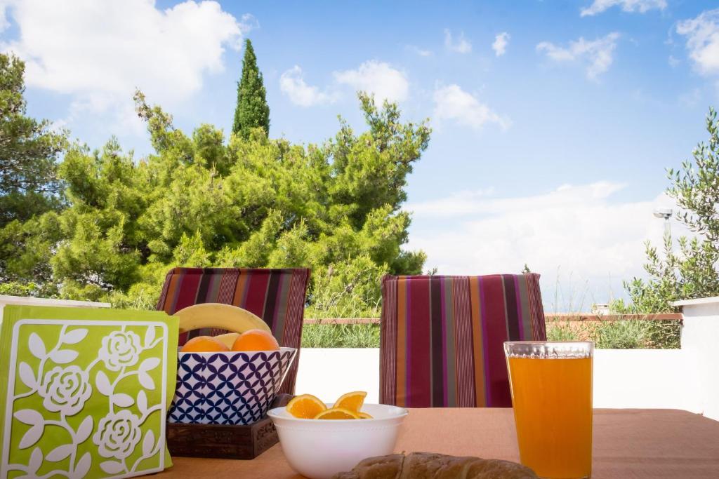 a table with a glass of beer and a bowl of fruit at Holiday Home Laurea in Supetar