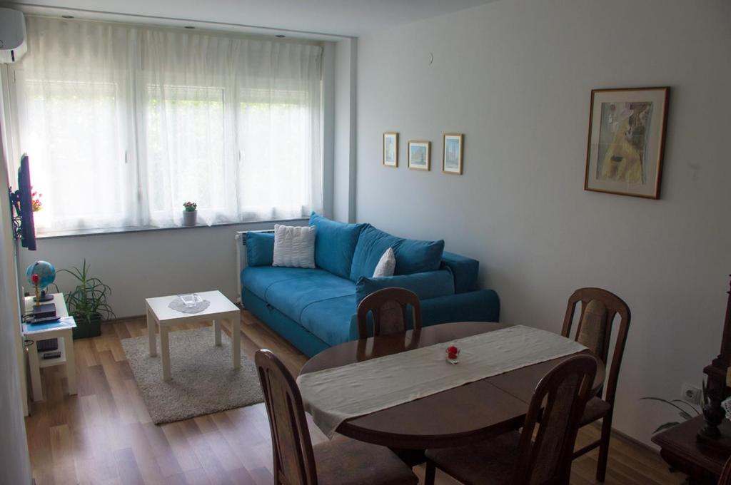 札格雷布的住宿－Meridian，客厅配有蓝色的沙发和桌子