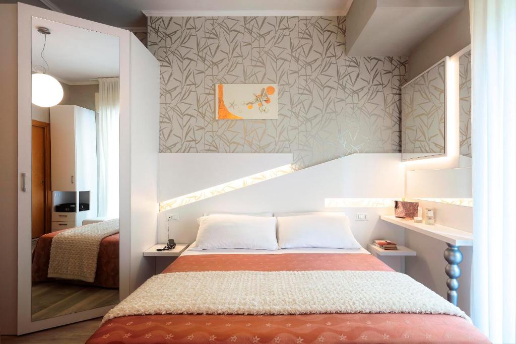 una camera con letto e parete di Hotel Ombretta Mare a Rimini