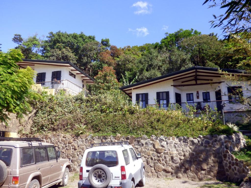 dois carros estacionados em frente a uma casa em Casitas Jeruti em Monteverde