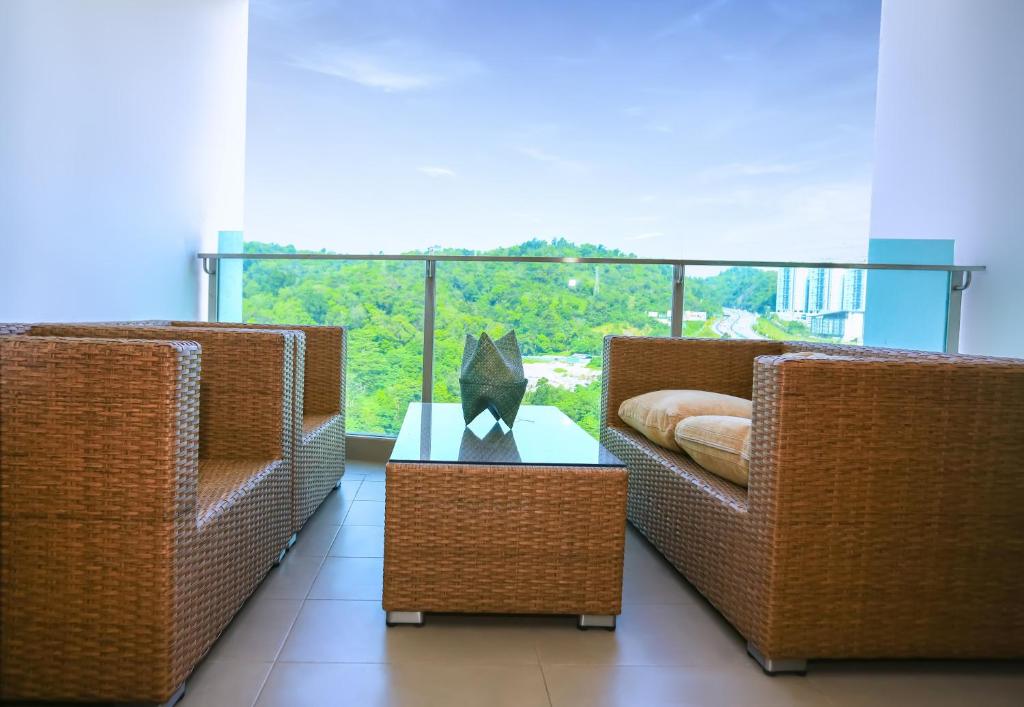 two wicker chairs and a table in front of a balcony at RK Suites in Kuala Lumpur