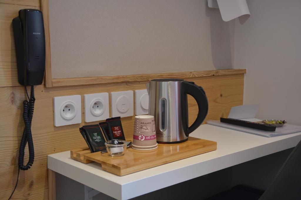 a coffee pot sitting on a counter with a phone at Hotel Le Faranchin in Villar-dʼArène