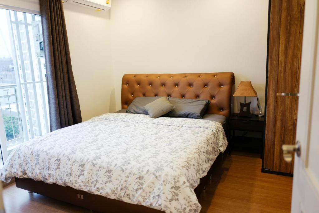a bedroom with a large bed with a large window at Gsuite Glamorous Apartment in Bangkok