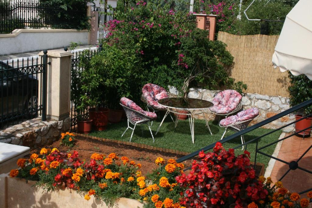 Selínia的住宿－Studio，庭院配有桌椅和鲜花
