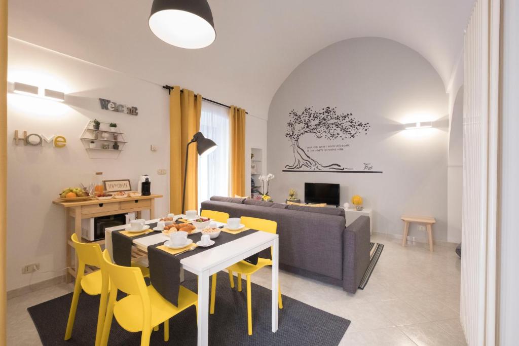 a dining room and living room with a table and yellow chairs at Terè in Noci