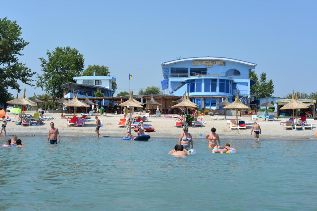 un grupo de personas en el agua en una playa en Hotel Hercules Jupiter en Jupiter