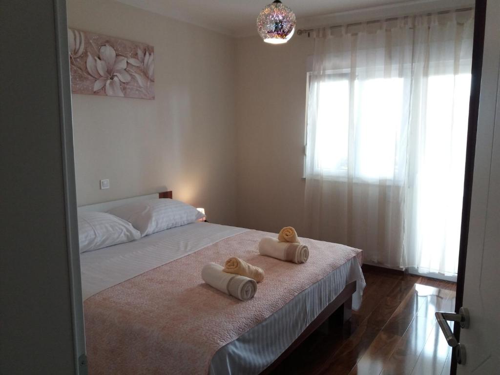 a bedroom with a bed with two teddy bears on it at Apartmani Katarina in Zadar