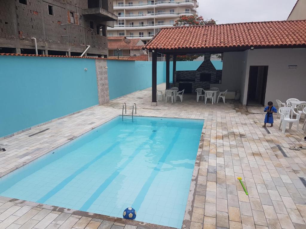 uma grande piscina azul ao lado de um edifício em Apartamento Cabo Frio Maciel em Cabo Frio