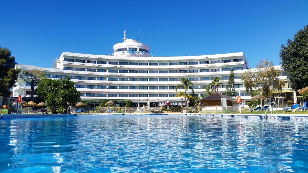 um hotel com piscina em frente a um edifício em TRH Paraíso em Estepona