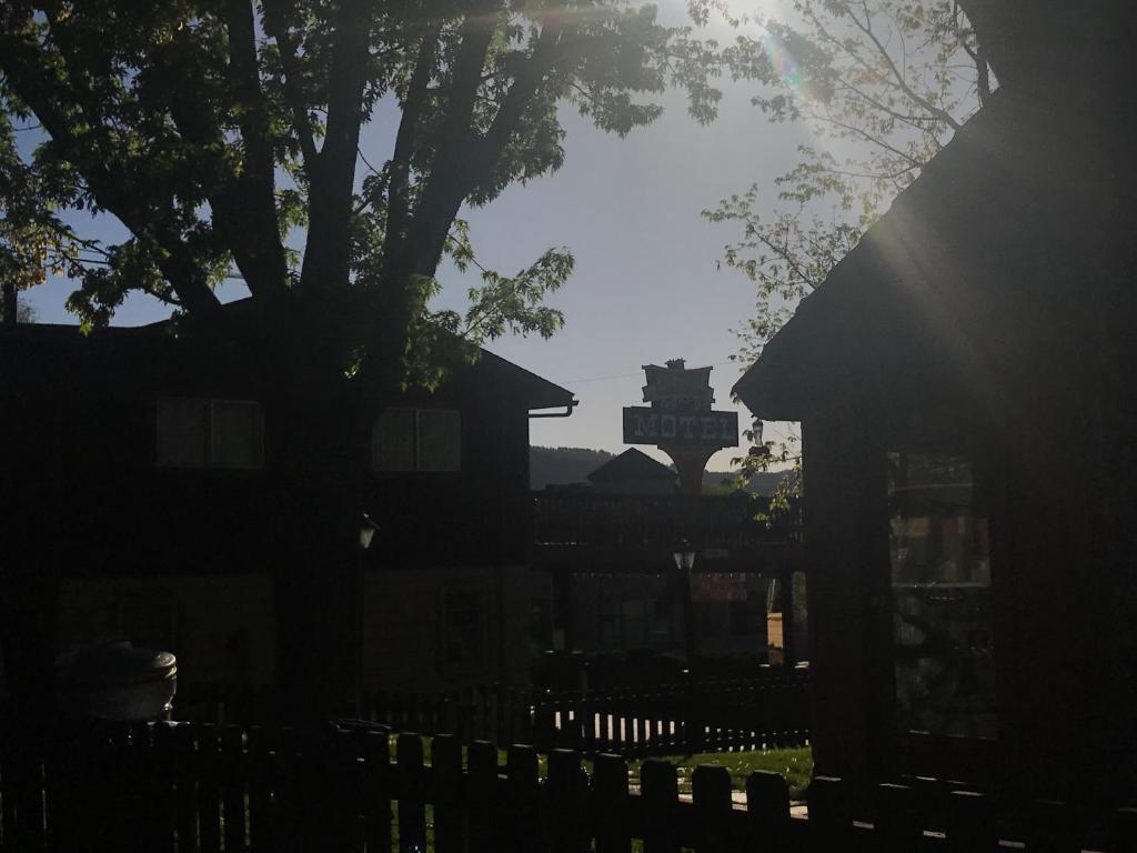a silhouette of a house with a fence and a tree at Caboose Motel & Gift Shop in Durango