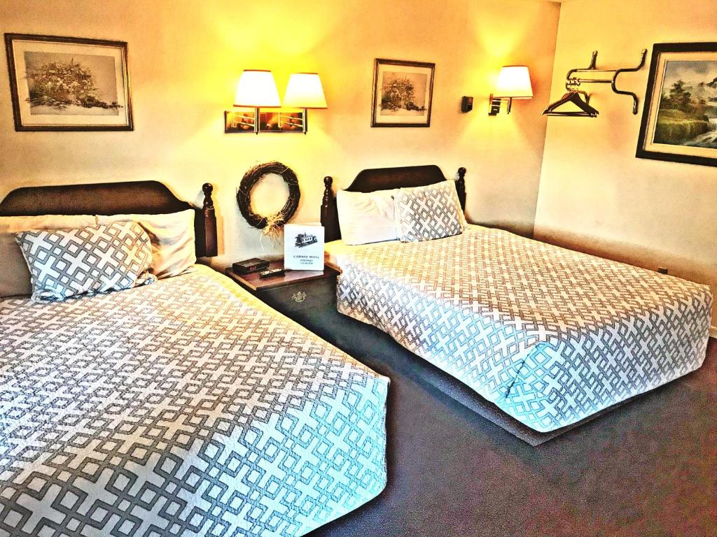 a hotel room with two beds and a mirror at Caboose Motel & Gift Shop in Durango