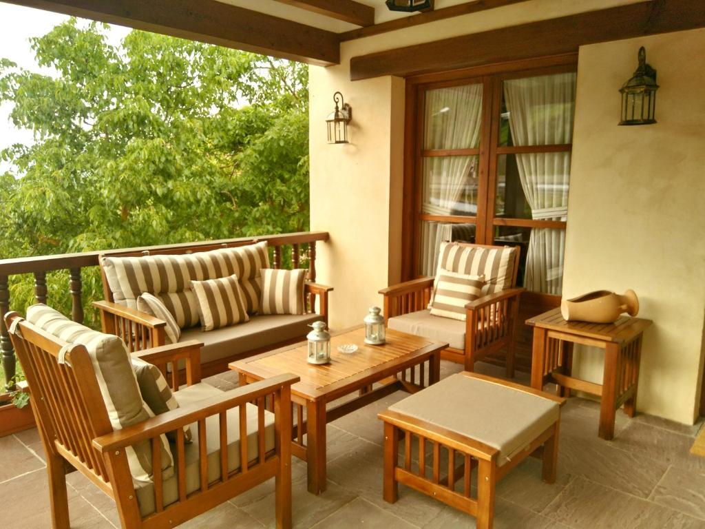 a porch with chairs and a couch and a table at Casa Fidela in Lomeña