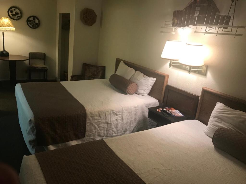 a hotel room with two beds and a lamp at Caboose Motel & Gift Shop in Durango