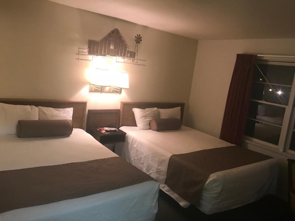 a hotel room with two beds and a window at Caboose Motel & Gift Shop in Durango