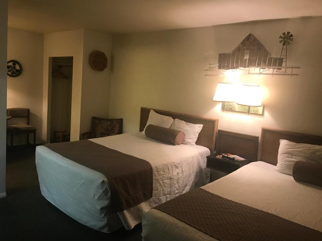 a hotel room with two beds and a lamp at Caboose Motel & Gift Shop in Durango