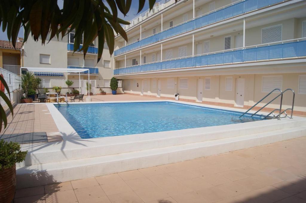a swimming pool in front of a building at Apartamentos San Miguel in Alcossebre