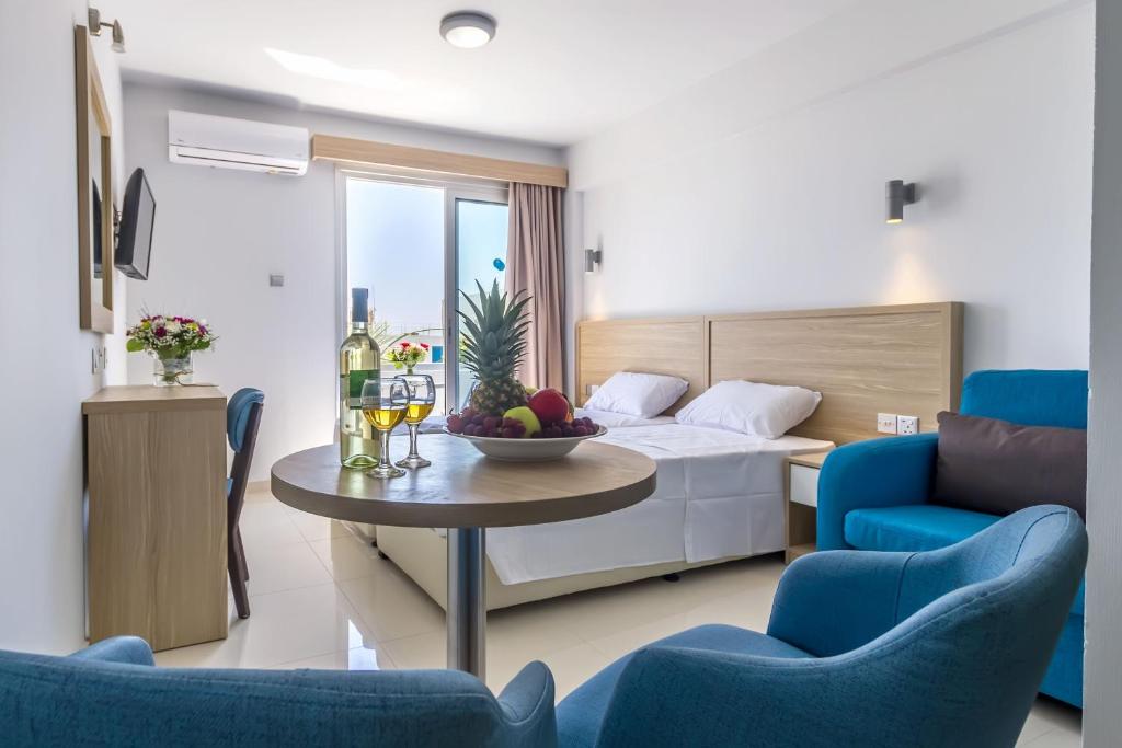 a hotel room with a bed and a table and chairs at Paul Marie Hotel Apartments in Ayia Napa