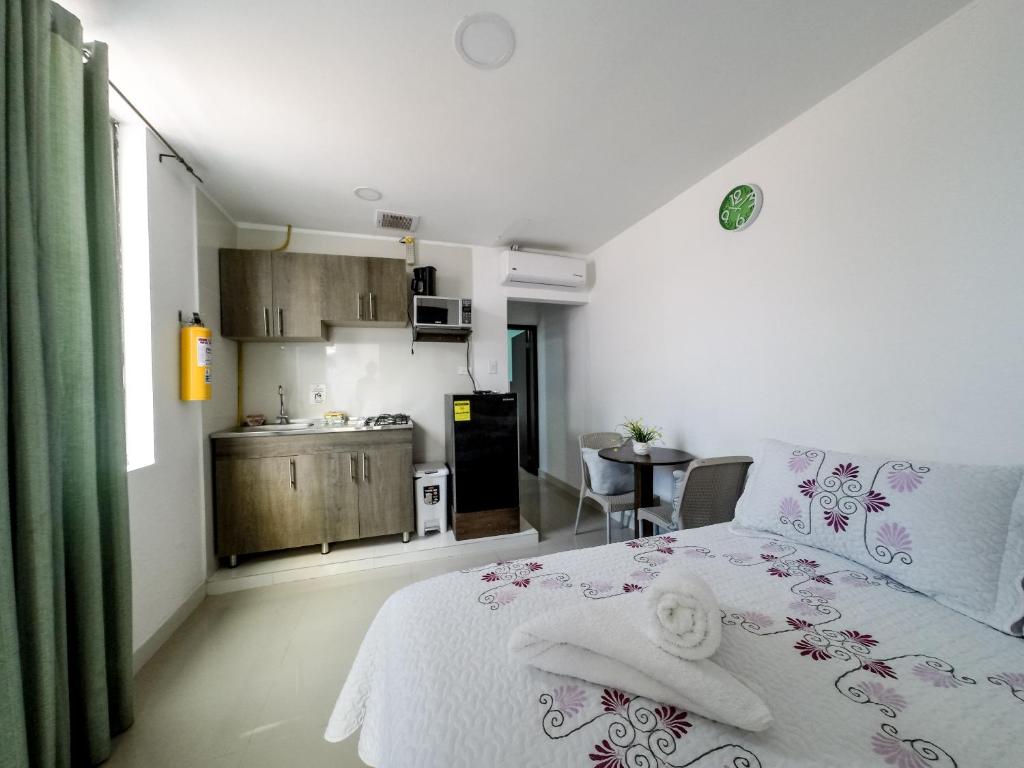 1 Schlafzimmer mit einem weißen Bett und einer Küche in der Unterkunft Apartahotel Bahia Tropical III in San Andrés