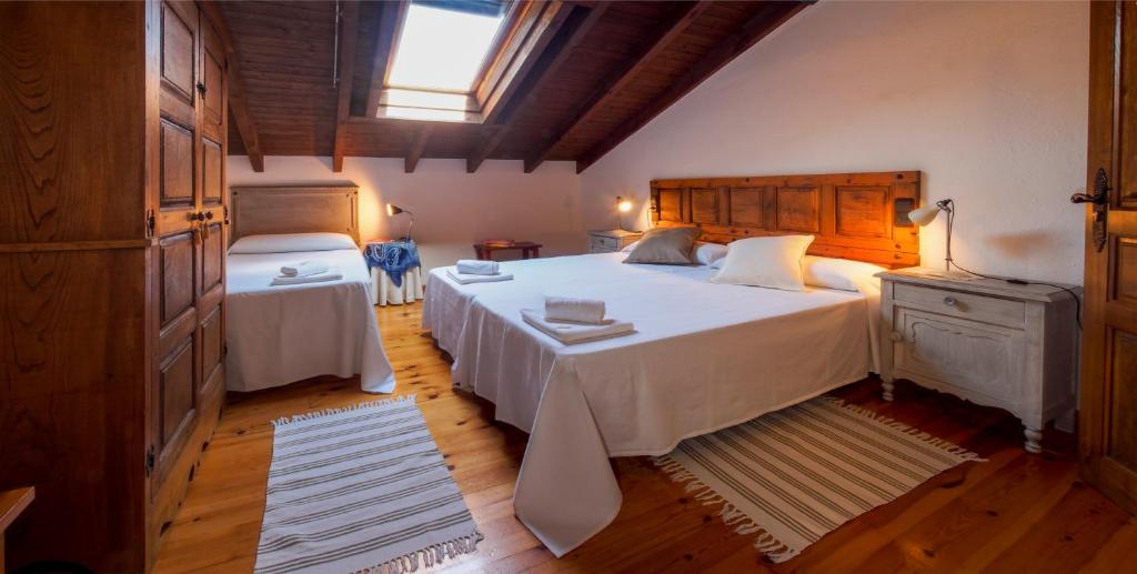 ein Schlafzimmer mit einem großen weißen Bett und einem Fenster in der Unterkunft Casa de la Montaña Albergue Turístico in Avín