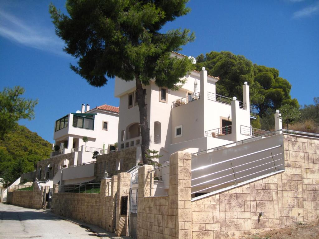 a white house on top of a stone wall at Villa Avra in Poros
