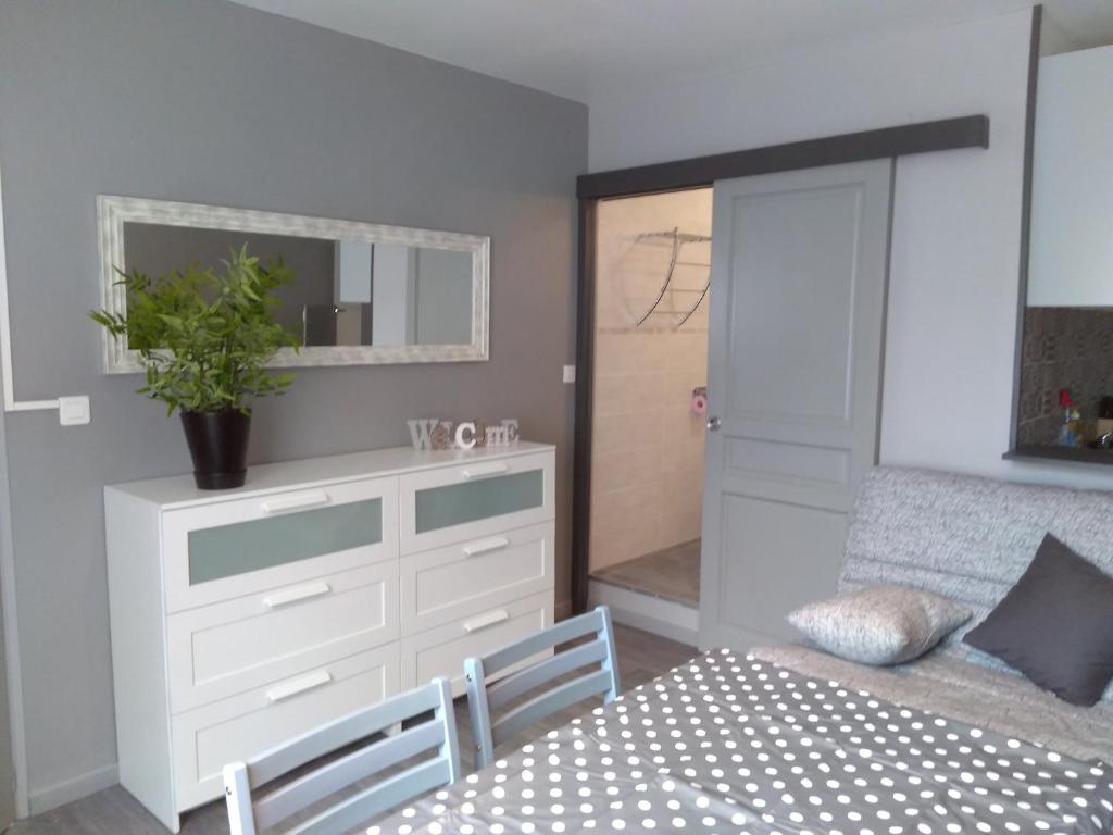 a bedroom with a bed and a dresser and a table at Les Studios proche du Mont Ventoux in Mazan