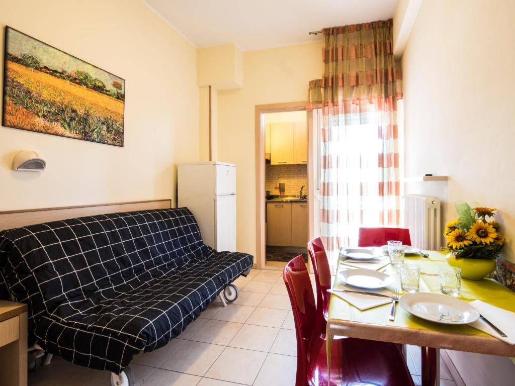a living room with a dining table and a couch at Appartamenti Lira in Cattolica