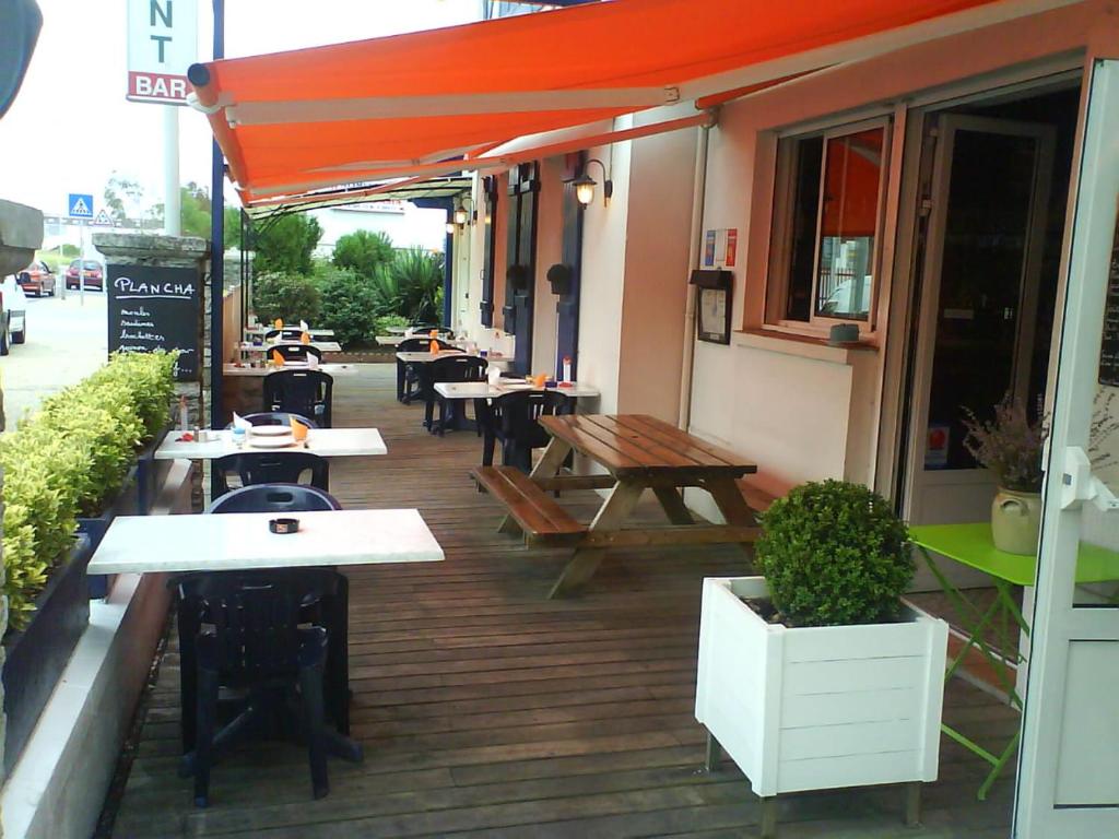zewnętrzne patio ze stołami i ławkami w budynku w obiekcie Hotel Chez Benat w mieście Anglet
