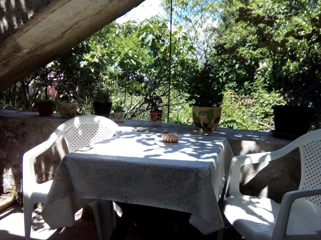 a table with a white table cloth and two chairs at Vicky Apartments in Kotor