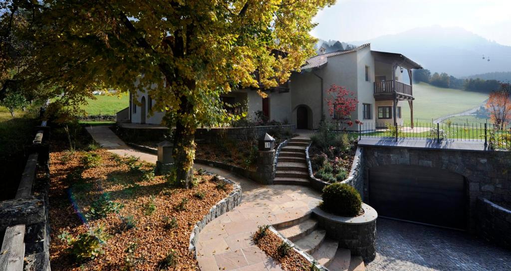 une maison avec un arbre et des escaliers en face de celle-ci dans l'établissement Villa Tilia, à Alpe di Siusi