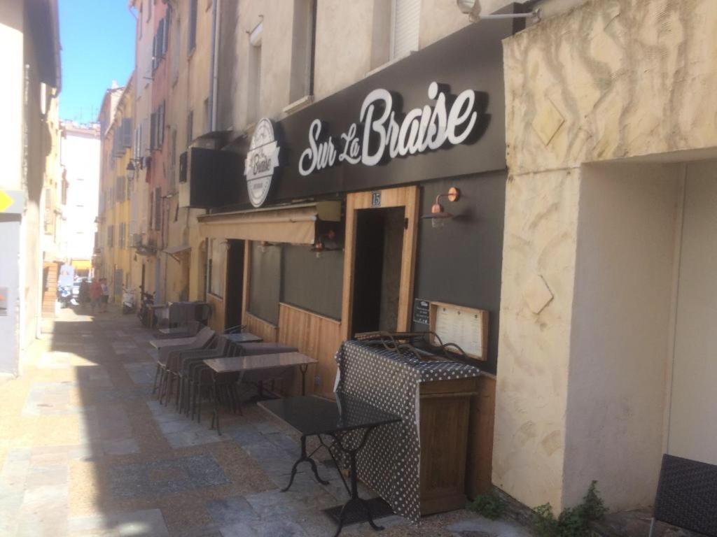 a restaurant with a sign on the side of a building at Studio loft avec terrasse centre historique in Ajaccio