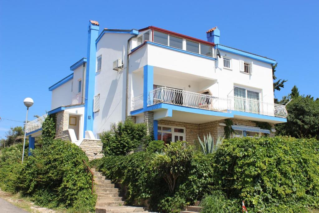 un edificio blu e bianco con scale che lo portano di Apartments Blue Sea a Mali Lošinj (Lussinpiccolo)