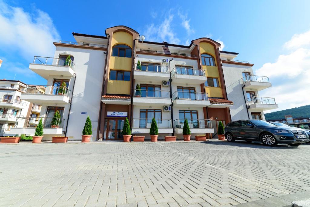 a building with a car parked in front of it at Stela Apartments in Obzor