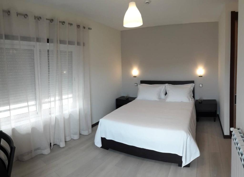 サン・ドミンゴス・デ・ラナにあるPousada Tires Guest Houseのベッドルーム(白いベッド1台、窓付)