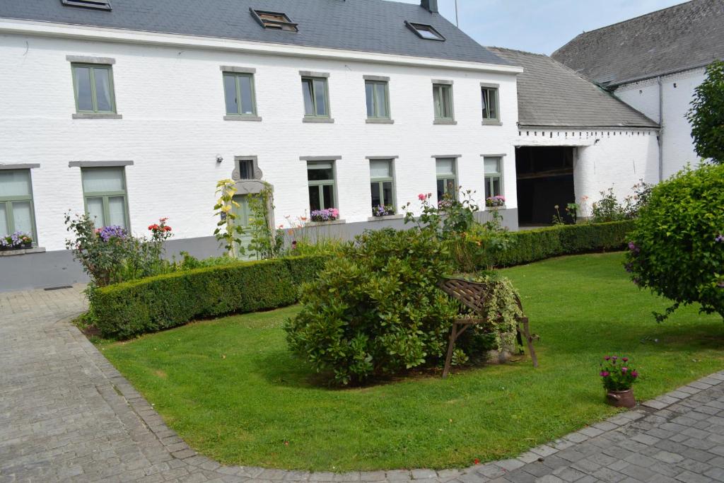 une maison blanche avec une cour devant elle dans l'établissement La Ferme Remue, à Rixensart