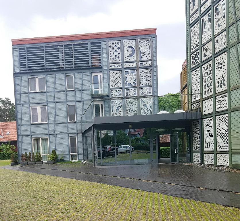 a large building with a glass entryway in front of it at Miško apartamentai 50m2 in Juodkrantė