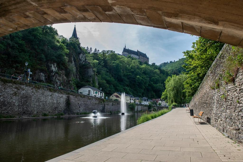 a bridge over a river with a water fountain at Hotel Belle Vue in Vianden