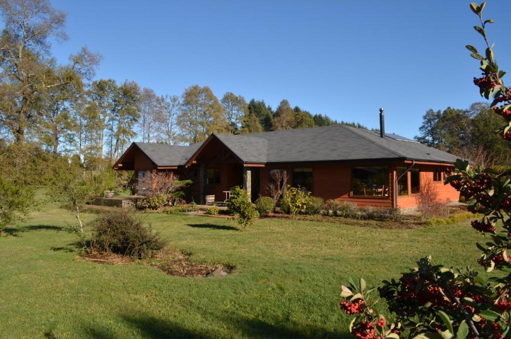 a house with a large yard in front of it at Outrippers Pucón in Villarrica