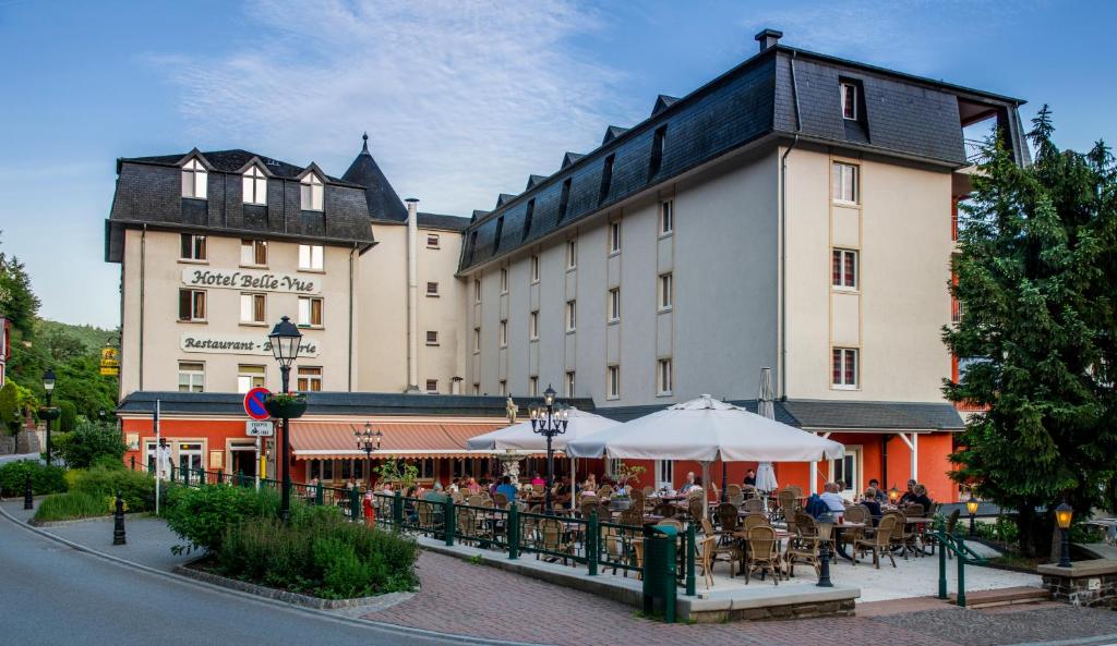 a building with people sitting at tables in front of it at Hotel Belle Vue in Vianden