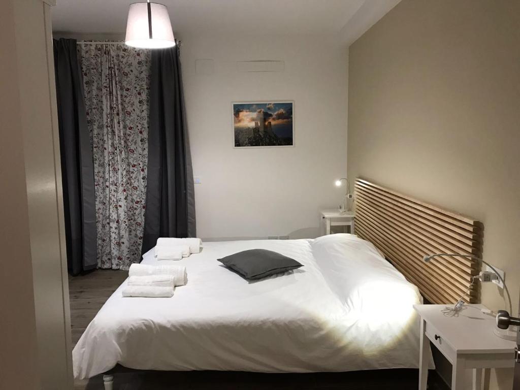 um quarto com uma cama branca e toalhas em Villa Lò em Chieti