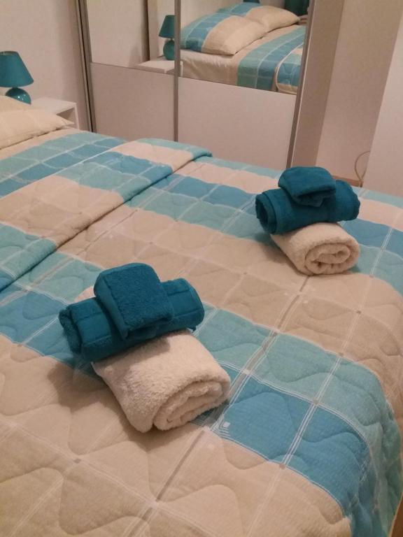 twee handdoeken op een bed voor een spiegel bij Apolonia Lux Apartment in Budva