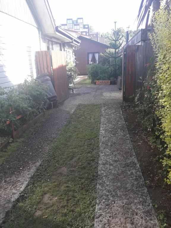 un patio trasero con una pasarela junto a una casa en Cabañas Mister Nelson, en Valdivia
