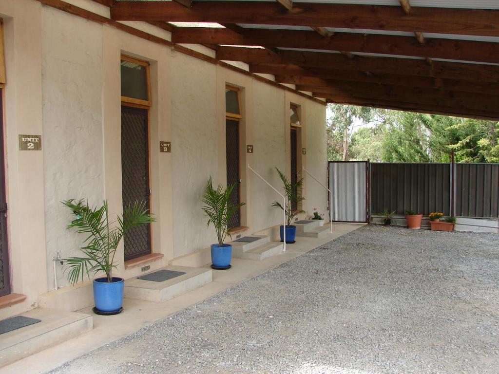 a porch with potted plants in blue pots on it at Truro weighbridge motel in Stockwell