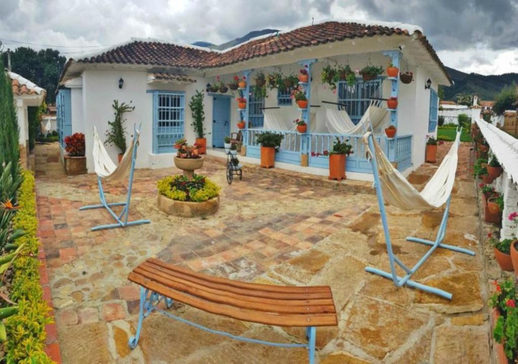 eine Terrasse mit einer Bank und Hängematten vor einem Haus in der Unterkunft Casa Hotel Santa Helena Boutique in Villa de Leyva