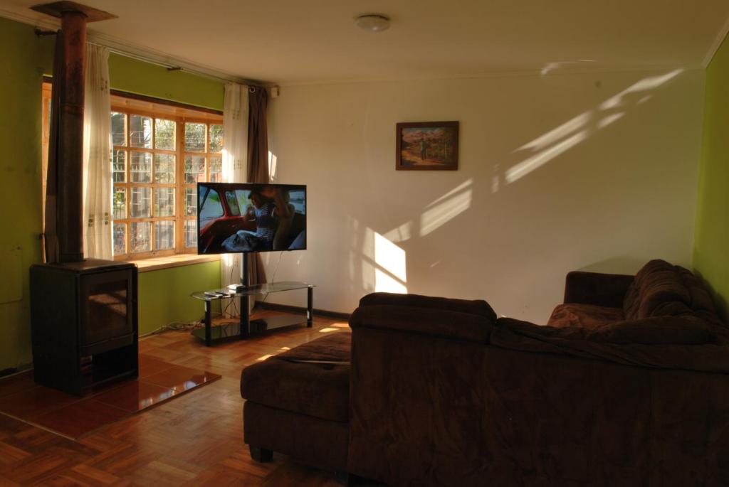 Una sala de estar con un sofá y un televisor de pantalla plana. en La Casa Toesca, en Valdivia