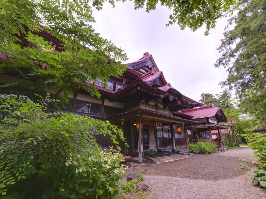 a wooden house with a red roof at Syohoen in Daisen