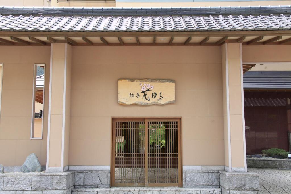 una puerta a un edificio con una señal encima en Ryotei Hanayura, en Noboribetsu
