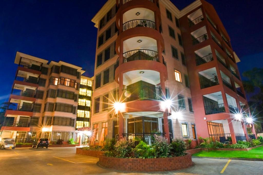 ナイロビにあるGemSuites Serviced Apartments State Houseの正面に照明がある高い建物