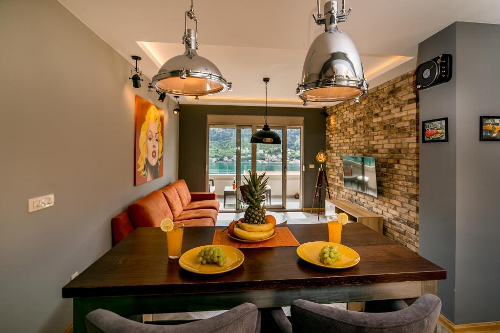 a dining room with a wooden table and chairs at Apartments Magic Sea View in Kotor