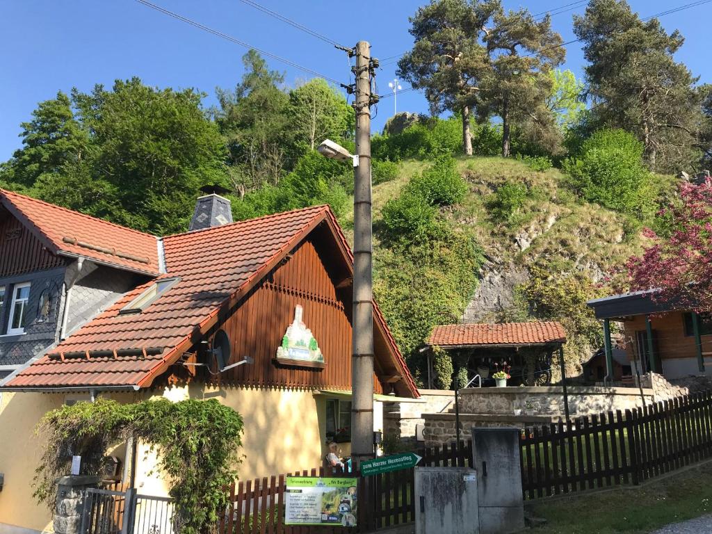 una casa con una valla al lado de una montaña en Ferienwohnung Am Burgberg en Rübeland